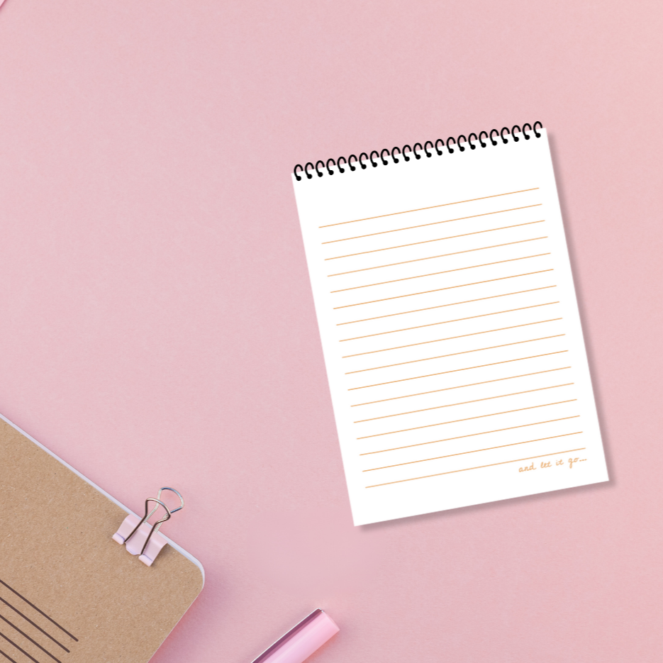 Notebook with lined pages on a pink background